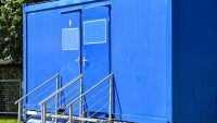 Blauer Toilettenwagen mit Treppe